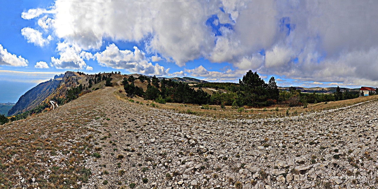 Ай-Петринская яйла вдоль дороги к пос. Охотничье. Слева белые полоски - крутой поворот Бахчисарайского шоссе (дорожный серпантин, "тёщин язык"). Справа - построенный, но не запущенный ветряк без лопастей.
