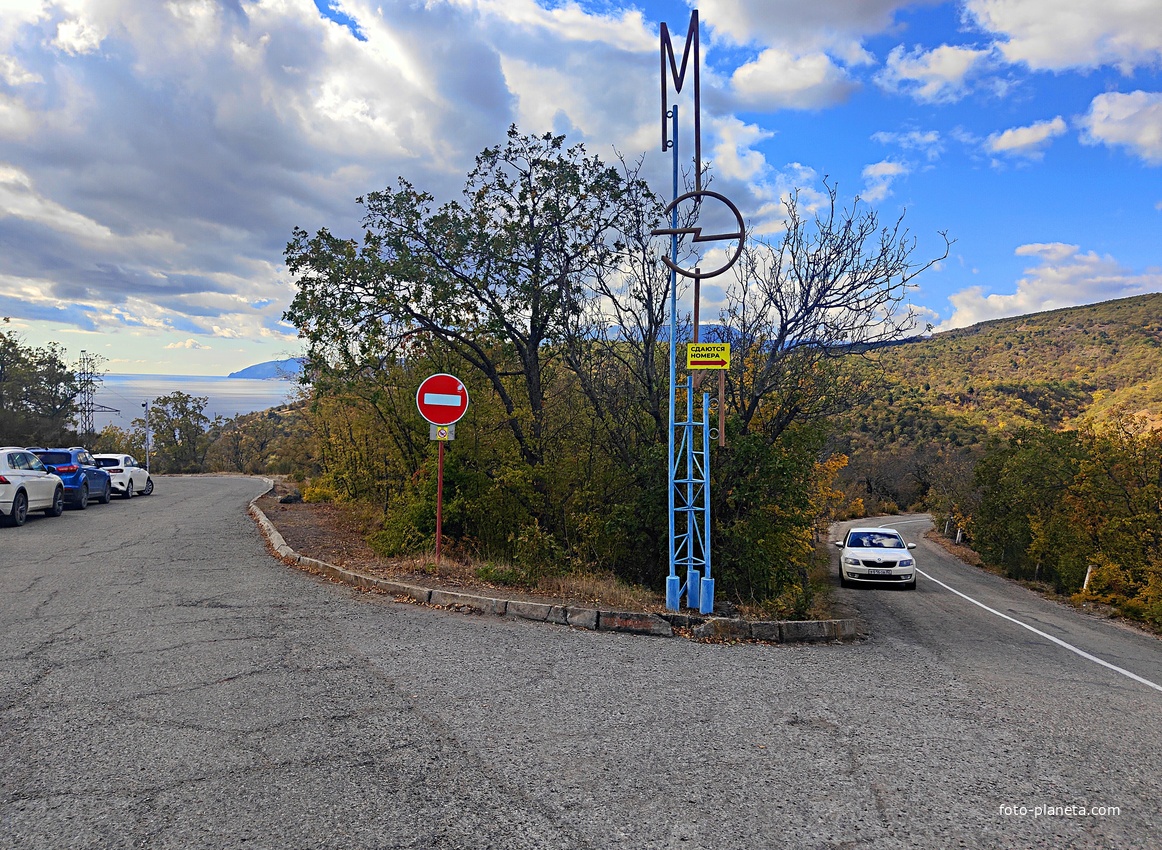 Стилизованная мачто-опорная стела МЭИ непосредственно пред отворотом дороги к СОСЛ МЭИ "Алушта" у побережья.