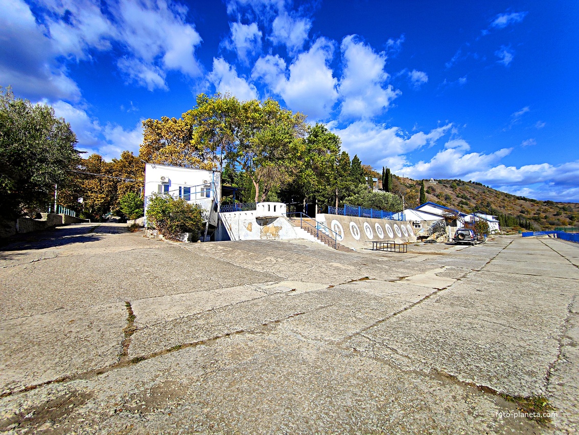 Площадка на набережной СОСЛ МЭИ "Алушта". Вид на "Эллинг" (кафе на набережной) и Эстраду, за ними "Дом у моря" и "Белый дом".