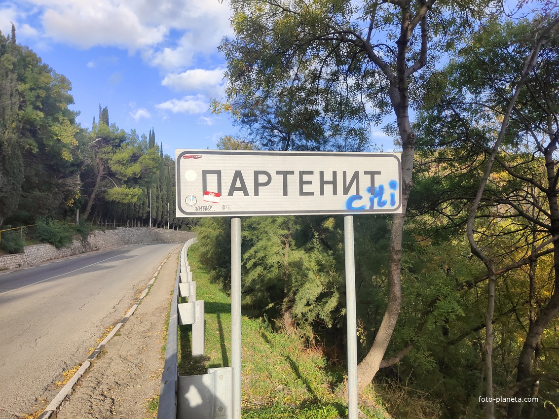 Дорожный указатель на дороге в посёлок