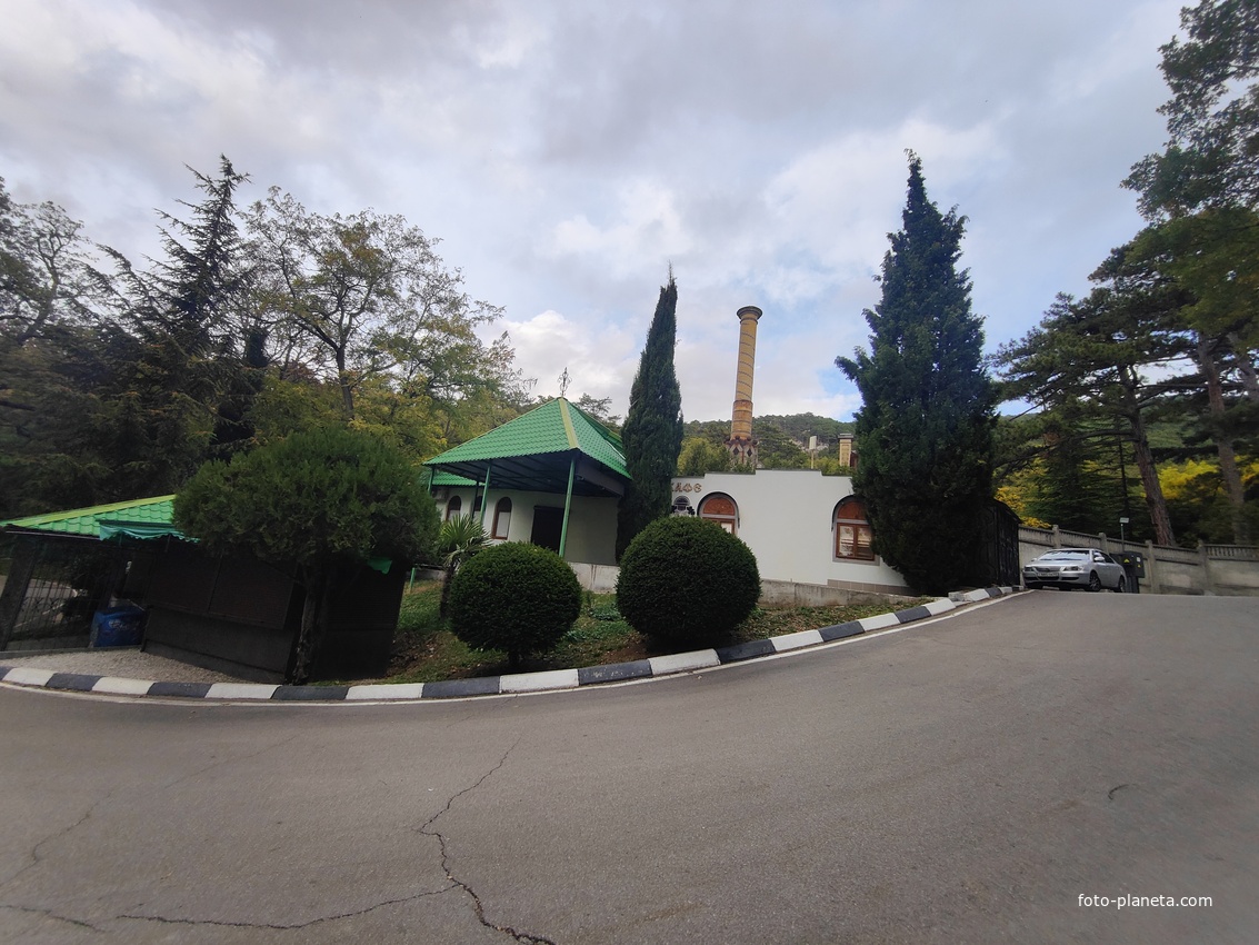 Массандровский дворцово-парковый ансамбль. Кафе внутри исторического здания дворцовой котельной.  Труба котельной стилизована архитектором Максимилианом Месмахером под минарет. Крыша постройки украшена черепицей, перекликающейся с декором дворца.