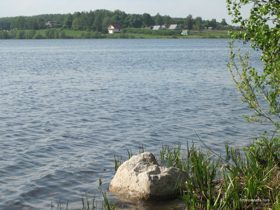 Вид на Рюмниково через озеро.