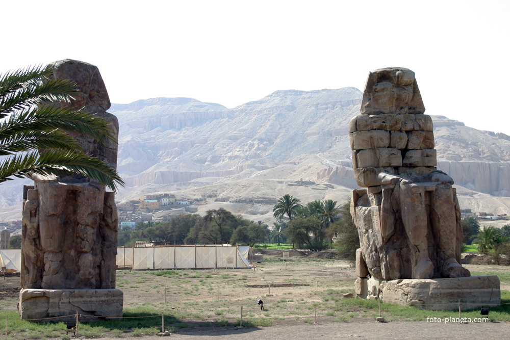 Статуи фараона Аменхотепа III (колоссы Мемнона) со статуями у его ног матери Мутемуя и жены Тие у его заупокойного храма