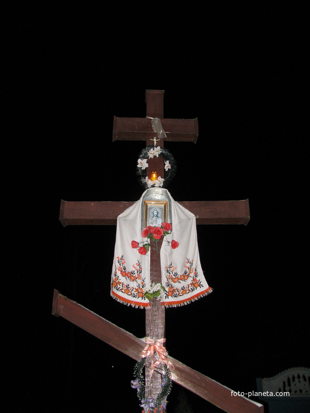 Придорожный крест украшенный рождественской лампадой