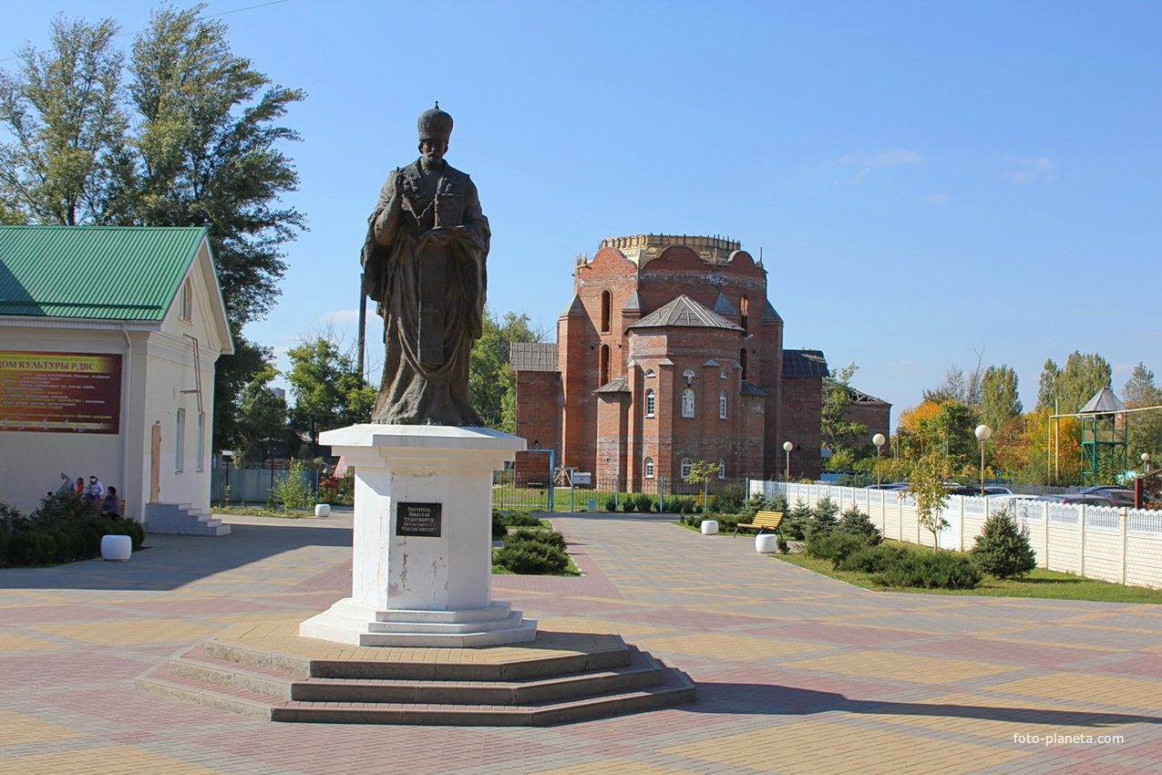 статуя Николая Чудотворца на фоне Свято-Никольского храма