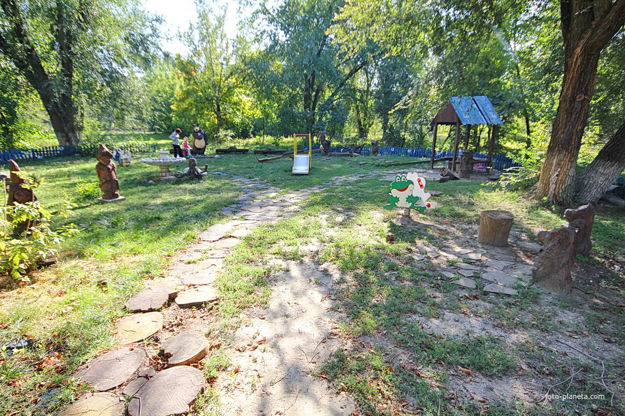 Детская площадка с деревянными скульптурами сказочных героев