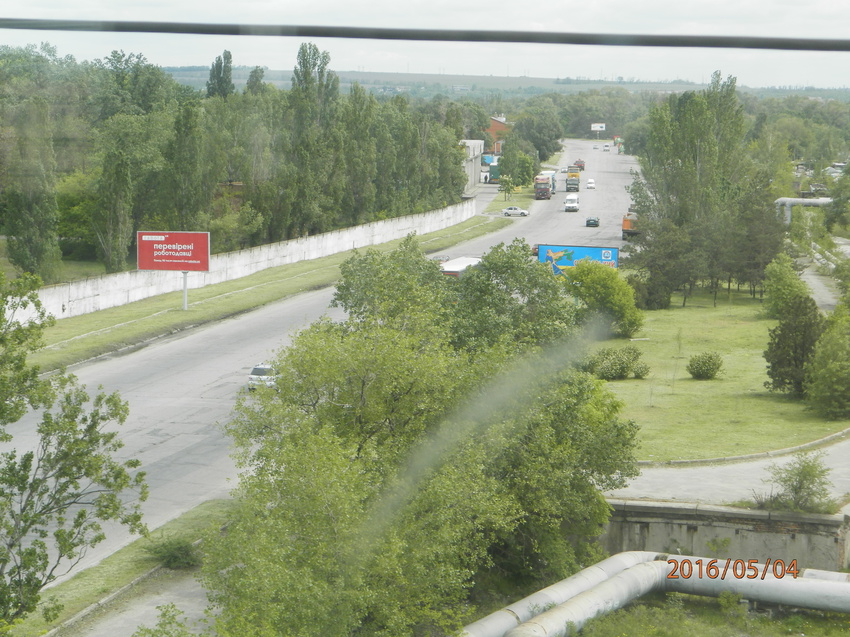 Из окна вагона.Поезд следует по Мерефо-Херсонскому мосту.Внизу-улица Малиновского на левом берегу.